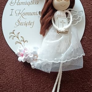 Aniołek komunijny, biały, z drewna i tkaniny, z napisem "Pamiątka I Komunii Świętej".